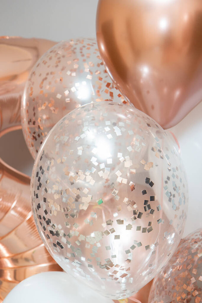 golden and white balloons on white background, rose gold helium balloons - Photo, Image