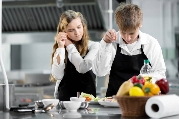 Students are learning to cook in a culinary institute with a standard kitchen and complete equipment. And have a professional chef as a trainer. - Фото, зображення