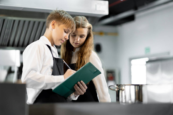 Uczniowie uczą się gotować w instytucie kulinarnym ze standardową kuchnią i pełnym wyposażeniem. I mieć profesjonalnego kucharza jako trenera. - Zdjęcie, obraz