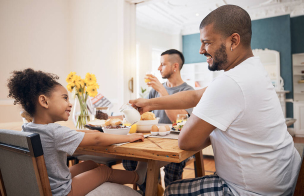Gay couple, home breakfast and family child smile for morning food, wellness and parents pour milk. LGBTQ, adoption and homosexual dad happy for hungry kid, youth girl or daughter eating cereal. - Foto, immagini