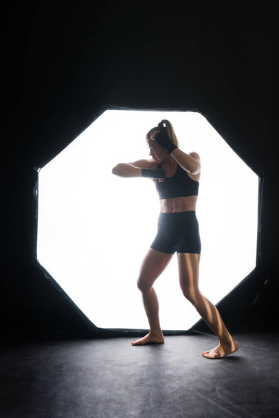 Fitness žena s červenými boxerskými obvazy a rukavicemi, foceno ve studiu - Fotografie, Obrázek
