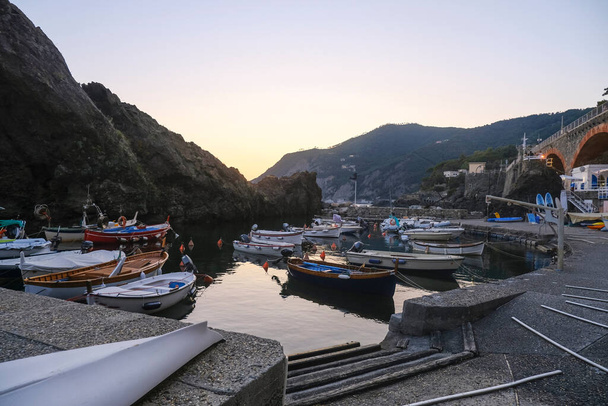 sunset over the Ligurian sea, cliffs, and boats on the waves in Framura, Italy. Marina at dusk - Photo, Image