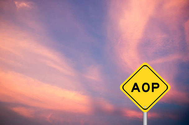 Yellow transportation sign with word AOP (abbreviation of Annual Operating Plan or Aspect-oriented programming) on violet color sky background - Photo, Image