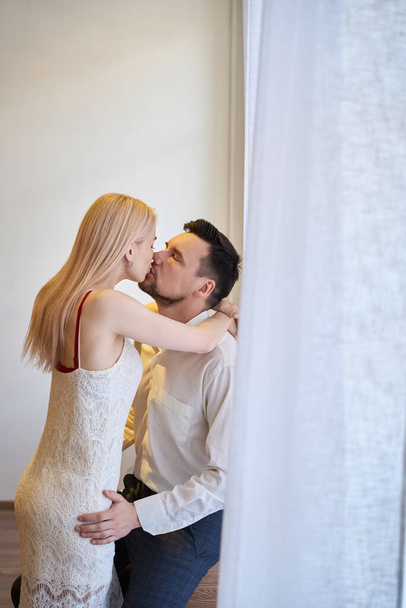 Sinnliche Frau in elegantem Kleid küsst ihren gutaussehenden Mann im Business-Anzug, Paar legitimiert ihre Beziehung, Liebe und Zärtlichkeit - Foto, Bild