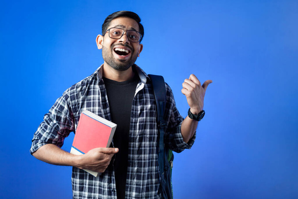 Happy adult student showing hand gesture against blue background. - Photo, image