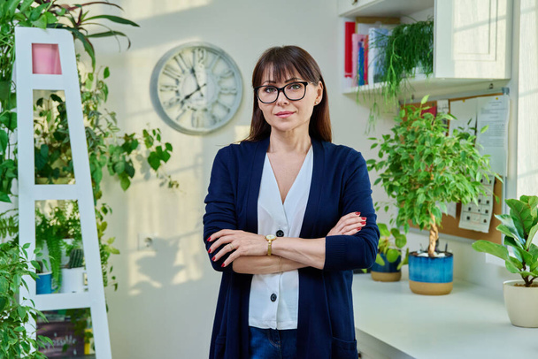 Portrait of business elegant middle-aged woman in office. Confident successful female with crossed arms looking at camera. Work, business, education, teaching, mature people concept - Foto, imagen