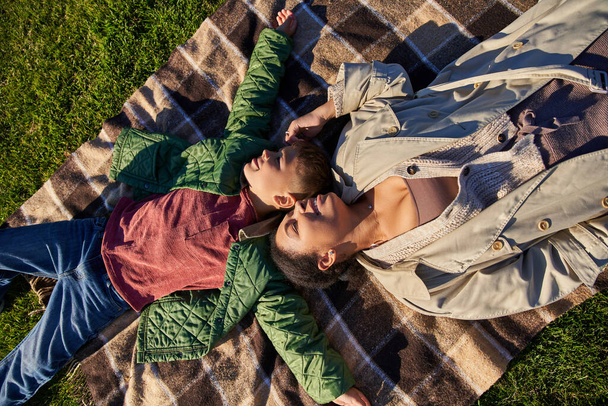Άποψη, ευτυχία, χαρούμενες αναμνήσεις, αφροαμερικάνικη μητέρα και γιος ξαπλωμένοι σε κουβέρτα, φθινόπωρο - Φωτογραφία, εικόνα