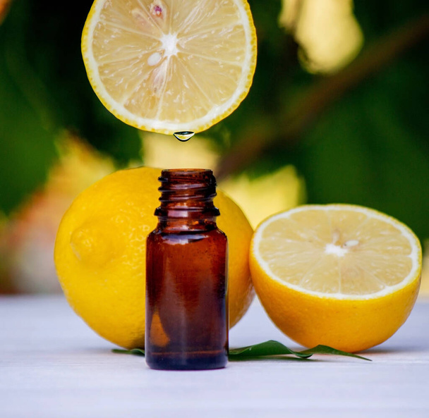 aceite esencial de limón y fruta de limón en una pizarra blanca de madera. Enfoque selectivo - Foto, imagen