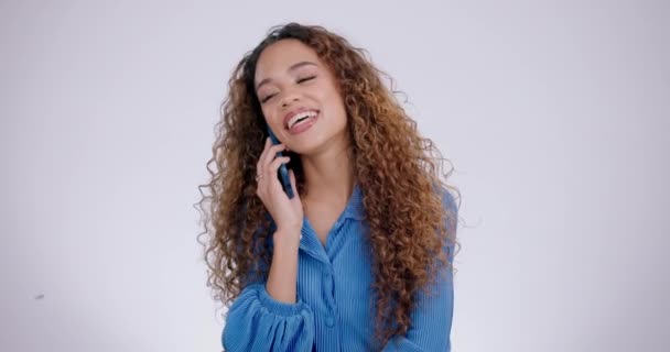 Vrouw, gelukkig en telefoongesprek voor communicatie, praten en netwerken op een witte achtergrond. Jonge en natuurlijke Afrikaan op mobiel of voip voor roddel, nieuws en grappig gesprek in de studio. - Video