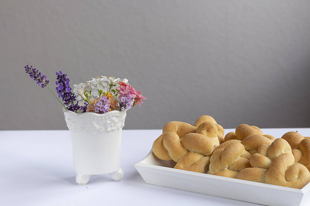 Букет з польових квітів і свіжої випічки. кренделі на сніданок - Фото, зображення