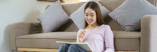 Mulheres pensando em plano de negócios para escrever notas enquanto trabalham no laptop no estilo de vida em casa. - Foto, Imagem
