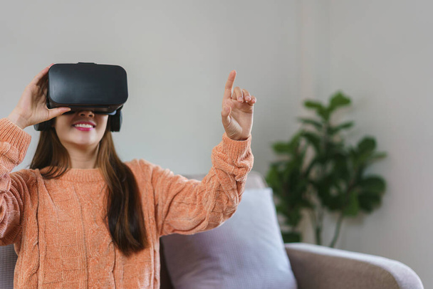 Kobiety dotykające się w powietrzu, aby cieszyć się doświadczeniem z wirtualnej rzeczywistości gogle i oglądania gier wideo. - Zdjęcie, obraz