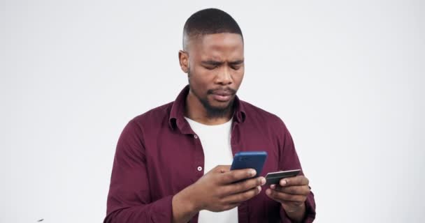 Phone, credit card problem or black man confused with password error, fintech glitch or omnichannel cyber security. Cellphone, phishing virus scam or studio person online shopping on white background. - Footage, Video