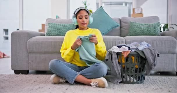 Laundry, happy and woman smell clothes with headphones for housekeeping, cleaning and washing. Home, living room and person with basket of clothing, fresh washing and fabric scent listening to music. - Footage, Video