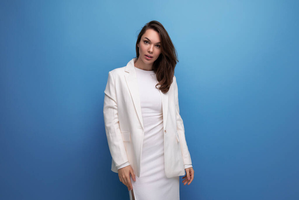 модная бизнес-леди в белом платье и пиджаке позирует на студийном фоне с копировальным пространством. - Фото, изображение