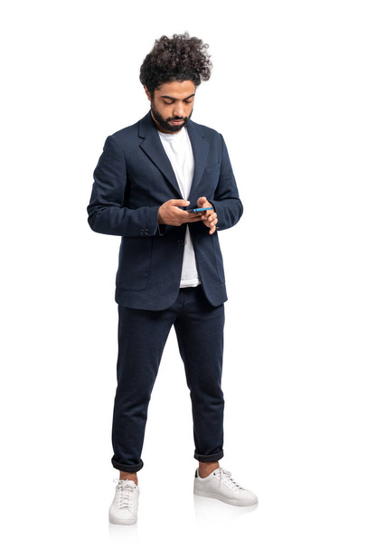 Lähi-idän liikemies täyspitkä tekstiviesti puhelimessa, mietteliäs mies eristetty valkoisella taustalla. Verkoston, sosiaalisen median ja viestinnän käsite - Valokuva, kuva