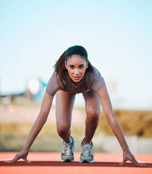 Woman, portrait and start of running athlete in sports fitness, exercise or motivation on stadium track. Serious female person or runner ready in race, sprint marathon or cardio workout and training. - Foto, Imagem