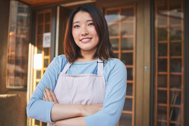 レストラン,コーヒーショップ,スタートアップストアで腕を持つハッピーでウェイトレスとアジアの女性. アイデア,笑顔,自信を持ったバリスタ,日本のカフェで従業員や中小企業の起業家を考える. - 写真・画像