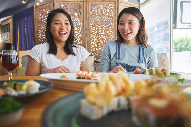 Szczęśliwe przyjaciółki, restauracja sushi i jedzenie z zaskoczeniem, śmiech komiczny, catering i talerz. Japońscy studenci, wow i podekscytowani rybami, owocami morza i jadłodajnią z odżywianiem, głodni i myślący. - Zdjęcie, obraz