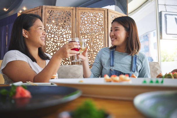 Mujeres japonesas, restaurante y tostadas con sushi, sonrisa y felicitaciones con buena comida, fiesta o pensamiento. Amigos asiáticos, felices y exitosos con el pescado, el alcohol o relajarse en el restaurante, el vino y gracias. - Foto, Imagen