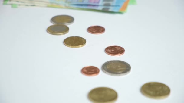 A woman counts euros, bills and coins while sitting at a white table. - Footage, Video