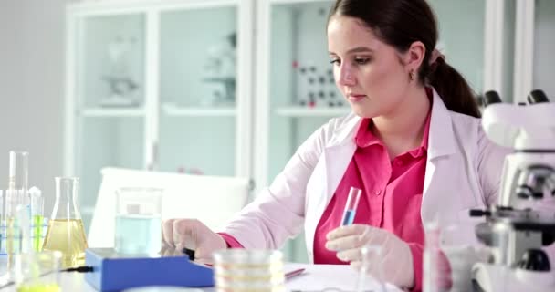 Laboratory practitioner works with samples and liquid in premise. Specialist in robe prepares for lab examination of liquids slow motion - Footage, Video