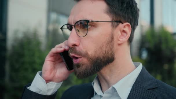 Lähikuva vihainen harmitti valkoihoinen mies liikemies toimisto johtaja puhua matkapuhelin ulkona huutaen kovaa konflikti väittävät ratkaista liiketoiminnan ongelma väärinkäsitys ärtynyt puhuva matkapuhelin kaupungissa - Materiaali, video