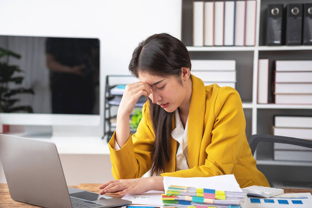 Fogantatás Burnout szindróma. Az ázsiai üzletasszony kényelmetlenül érzi magát munka közben. Amit a stressz okoz, a sikertelen munka és a kevésbé pihentető test. Forduljon pszichiáterhez.. - Fotó, kép