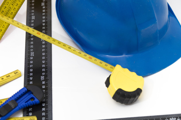Разноцветные шлемы и инструменты для строительных чертежей и сборки
 - Фото, изображение