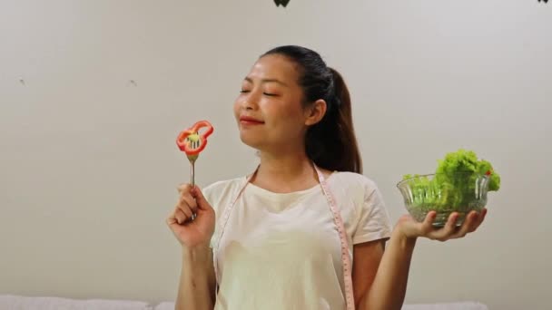 Sağlıklı ve yağsız bir öğle yemeği için besleyici dolmalık biber ve taze sebze yiyen genç Asyalı kadın: Sağlık hizmeti, yağ diyetini azaltma ve kilo verme. - Video, Çekim