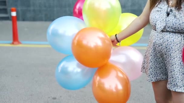 Eine Luftballonschnur, die zwischen Bäumen in einem Park für eine Geburtstagsparty im Freien hängt. Nahaufnahme. - Filmmaterial, Video