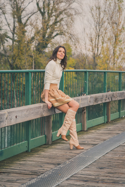 Beautiful young woman posing on a bridge - Photo, Image