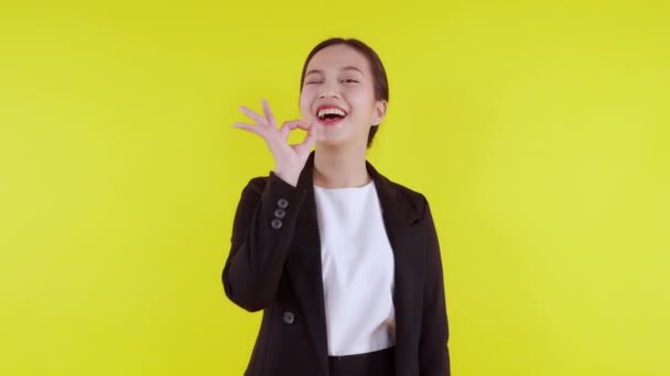 Portrét mladé asijské obchodní žena prezentaci a gesto ok izolované na žlutém pozadí, reklama a marketing, výkonný a manažer, podnikatelka sebejistý představení s výrazem. - Záběry, video