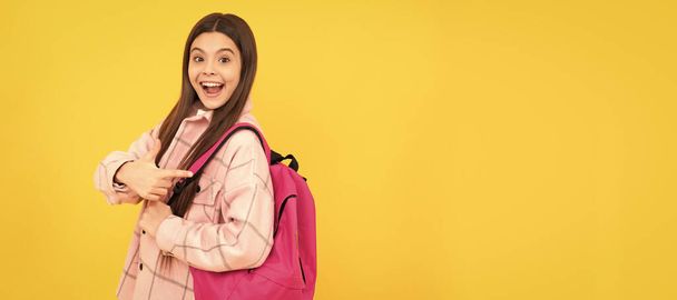 Z powrotem do szkoły. zaskoczony nastolatka dziewczyna w szachownicy koszuli. Plecak w stylu happy kid casual. Sztandar uczennicy. Portret uczennicy z przestrzenią do kopiowania - Zdjęcie, obraz