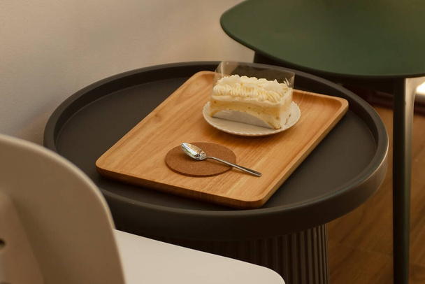 Metalowe łyżki i białe kremowe ciasta są po prostu umieszczone na stole. - Zdjęcie, obraz