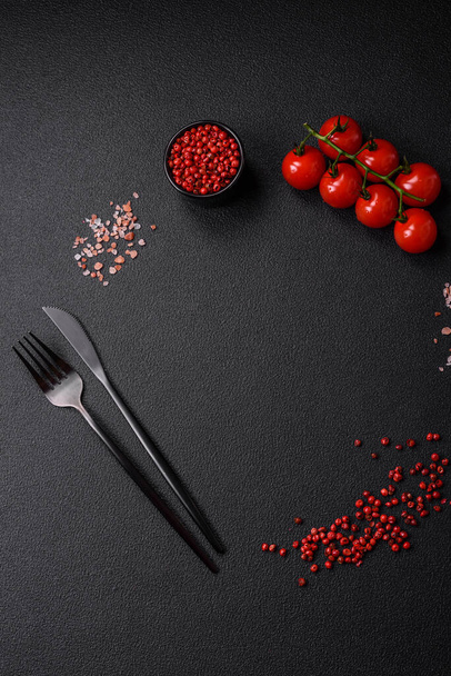 Πεντανόστιμη φρέσκια, ζουμερή ελληνική σαλάτα με φέτα, ελιές, ντομάτες, αγγούρι, πιπέρι, αλάτι και μπαχαρικά σε σκούρο μπετόν φόντο - Φωτογραφία, εικόνα