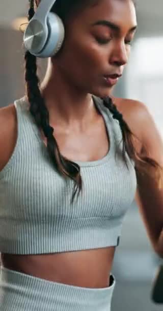 Fitness, headphone and a woman with a watch at gym for running, progress and time. Indian athlete person listening to music, podcast or audio on health app for exercise motivation, focus and wellness. - Footage, Video
