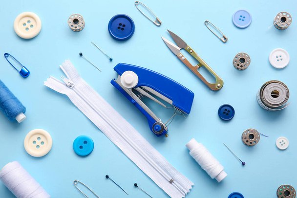 Macchina da cucire manuale con diverse forniture su sfondo blu - Foto, immagini
