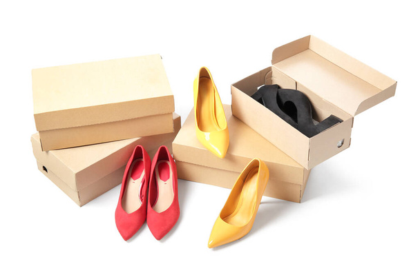 Cajas de cartón con diferentes zapatos femeninos aislados sobre fondo blanco - Foto, Imagen