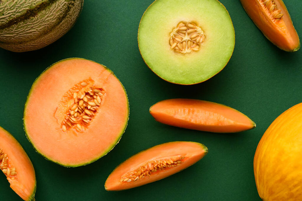 Lekkere rijpe meloenen op groene achtergrond - Foto, afbeelding
