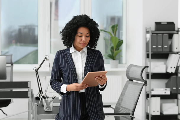 Young businesswoman using tablet in modern office - Foto, Bild