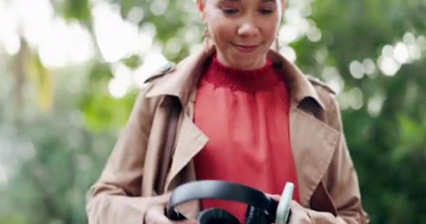 Ακουστικά, τηλέφωνο ή γυναίκα στο πάρκο χορό, περπάτημα ή streaming ένα τραγούδι, ήχο ή ραδιόφωνο υπηρεσία για να χαλαρώσετε. Κινητό, ακουστικά ή άτομο που ακούει μουσική σε απευθείας σύνδεση συνδρομή στη φύση για ευεξία. - Πλάνα, βίντεο