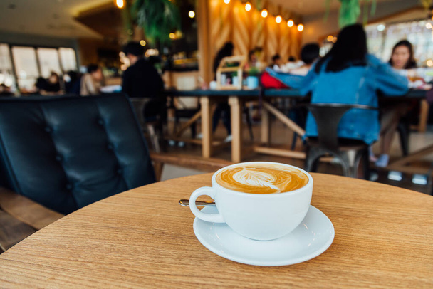 Top näkymä Latte tai cappuccino kahvi puunlehti rakenne puupöydälle
 - Valokuva, kuva