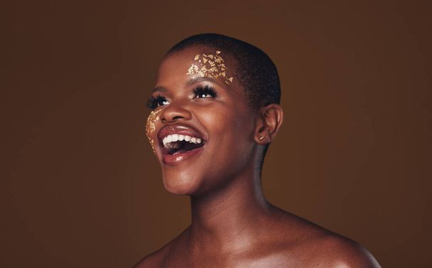 Χρυσό, μακιγιάζ και γυναίκα γελάνε με ομορφιά και πολυτέλεια και δημιουργική μάσκα spa. Glitter, τέχνη δερματολογία και Αφρικής θηλυκό πρόσωπο ευτυχής από την περιποίηση της επιδερμίδας και χρυσά καλλυντικά στο στούντιο. - Φωτογραφία, εικόνα