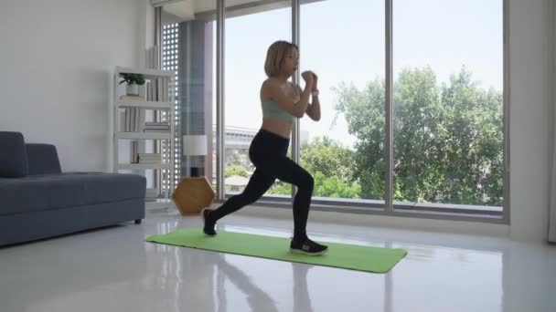 Asiatico donna allenamento da practicing split squat a casa - Filmati, video