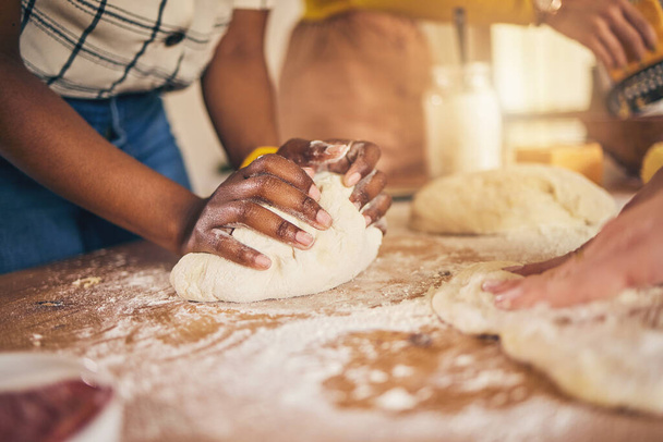Bakery, hands and baking by people or chef on a kitchen table cooking bread, pizza or pastry with dough. Culinary, counter and person preparing food at a restaurant with ingredient or recipe. - Photo, Image