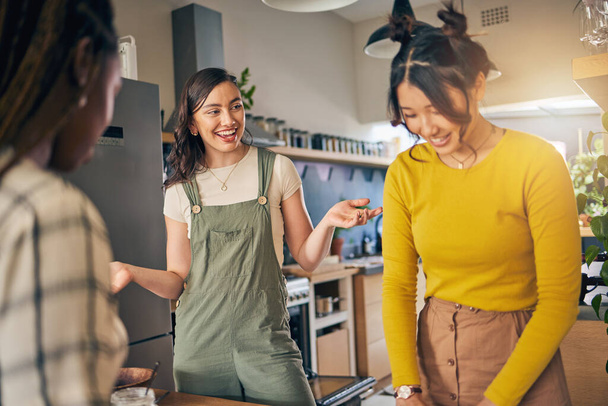 Conversación, vinculación y amigas en la cocina de su nuevo apartamento divirtiéndose juntas. Feliz, sonrisa y grupo de mujeres jóvenes hablando y cocinando una comida para el almuerzo o la cena en un hogar moderno. - Foto, imagen