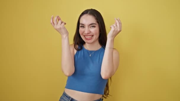 jong mooi latino vrouw glimlachen zelfverzekerd doen geld uitgeven gebaar over geïsoleerde gele achtergrond - Video