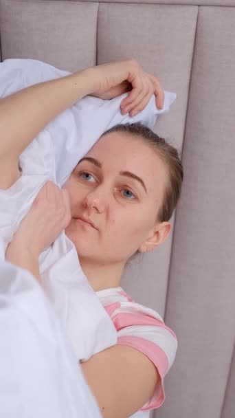 Самотня, засмучена жінка може заснути, має проблеми зі сном. Тривожний і депресивний стан у молодої жінки. Вертикальне відео - Кадри, відео