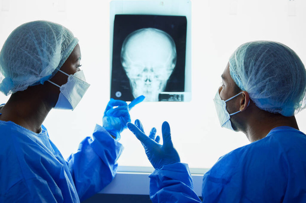 Fej röntgen, orvosok és orvosi vita tervezési vizsgálati eredmények, diagramok és tanácsadás szakértői elemzés. Radiológia, neurológia és sebész csapat ellenőrizze a koponya röntgen, anatómia és felülvizsgálat MRI műtét. - Fotó, kép